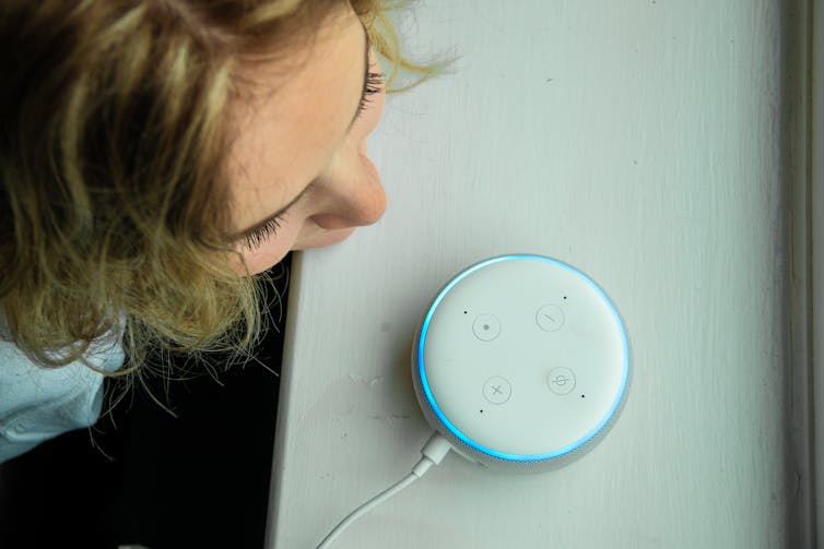 A child by a home voice assistant