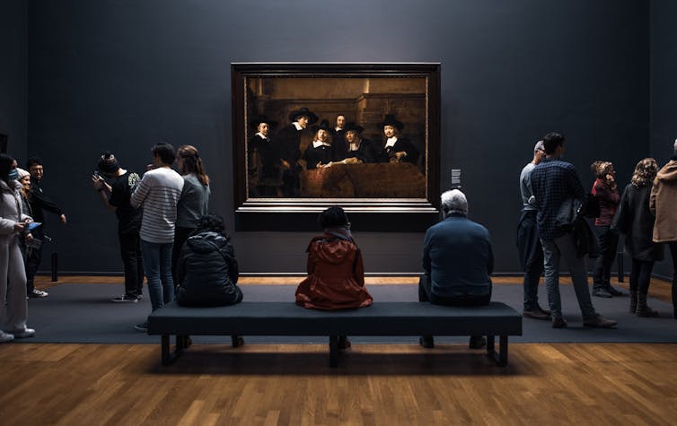 Visitantes observan el cuadro _Los síndicos de los pañeros_ del pintor neerlandés Rembrandt en el Rijksmuseum de Ámsterdam.