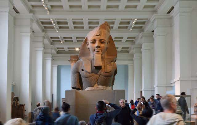 A large ancient Egyptian statue on display in a museum.