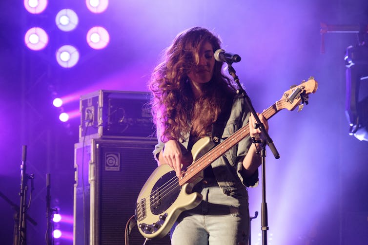 A woman plays a guitar