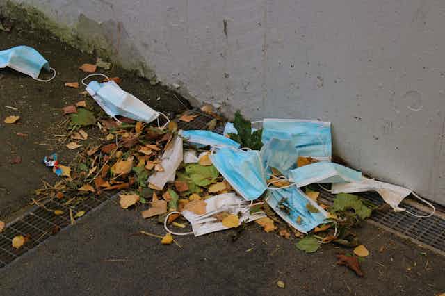 used surgical masks collect in a gutter