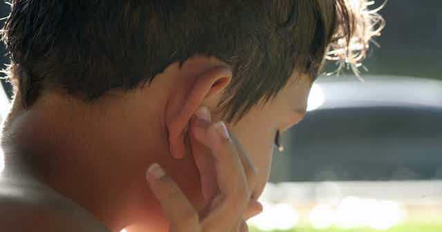 child touching ear