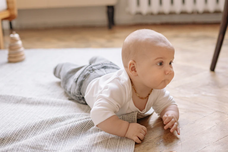 Baby crawling over rug on floor of a room