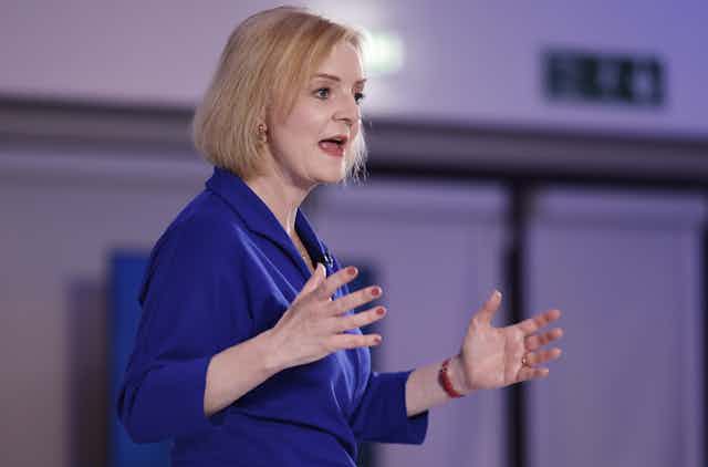 Liz Truss gestures with both hands while speaking during a hustings event 