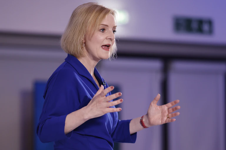 Liz Truss gestures with both hands while speaking during a hustings event