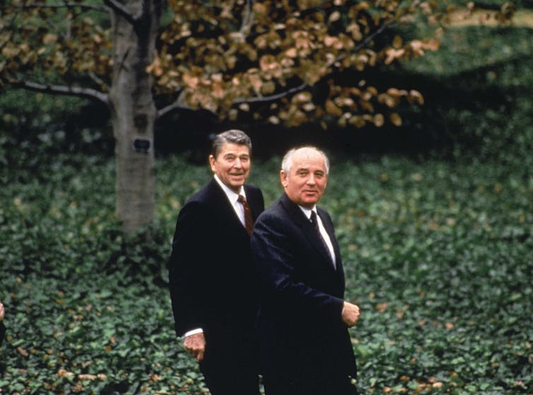 Mikhail Gorbachev and Ronald Reagan look at the camera while out for a stroll.
