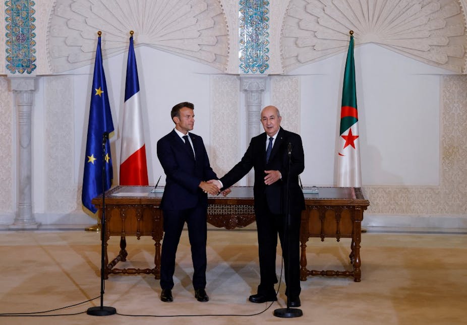 Emmanuel Macron et Abdelmadjid Tebboune se serrant la main lors d'une cérémonie à Alger.