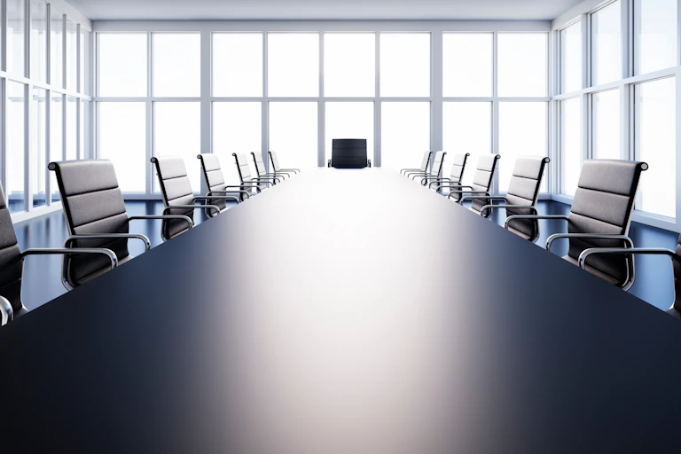 A black-and-white photo of an empty boardroom.