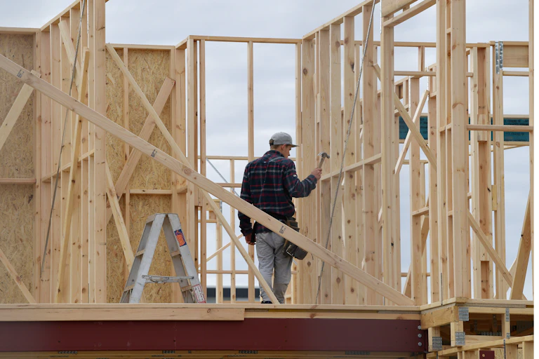 Man works on timber building frame