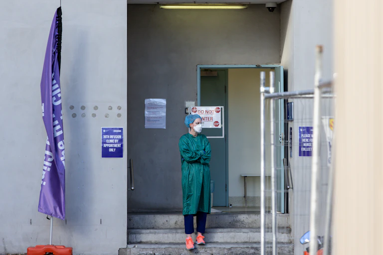A nurse takes a break outside a hospital