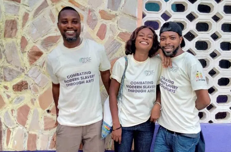 Three smiling people wearing T-shirts that say Act For Change.