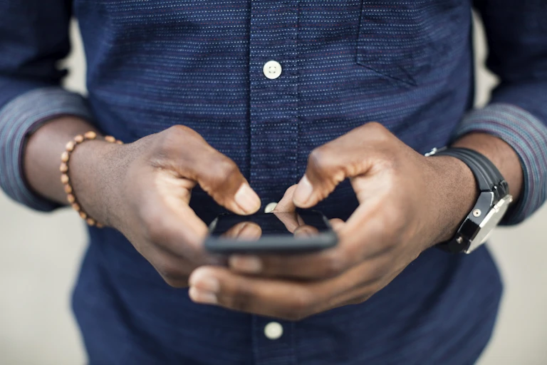 Midsection of a man using a mobile phone.
