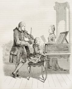 A black and white sketch shows a family in old European clothing. A young boy plays a piano while a man stands playing a violin behind him. A girl stands beside the piano holding a music sheet.