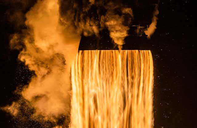 A waterfall of orange flames shooting out of rocket nozzles at launch