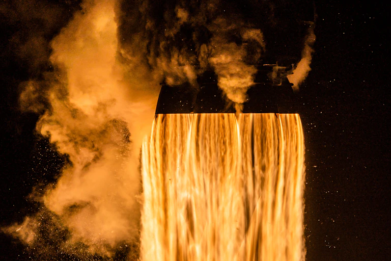 A waterfall of orange flames shooting out of rocket nozzles at launch