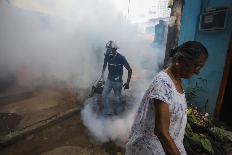 person spraying chemicals in urban setting
