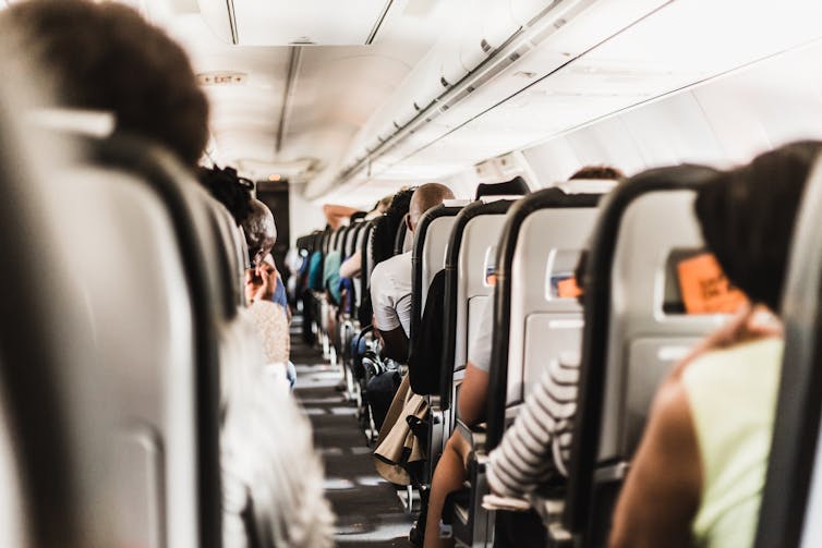 People sitting in the plane without wearing a mask