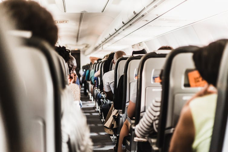 People sitting on plane not wearing masks