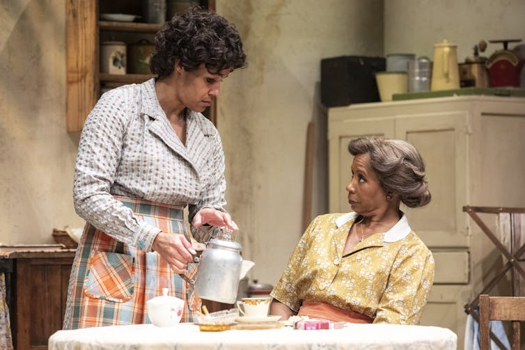 Two women at a kitchen table.