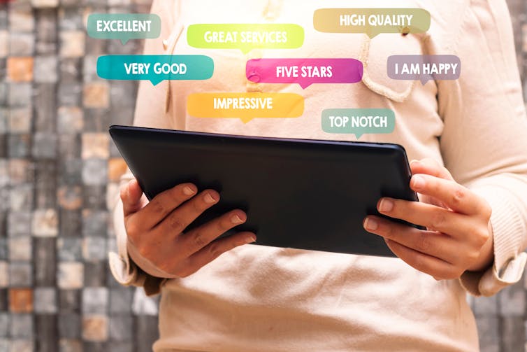 Conceptual picture showing person with a tablet with numerous review words jumping out.