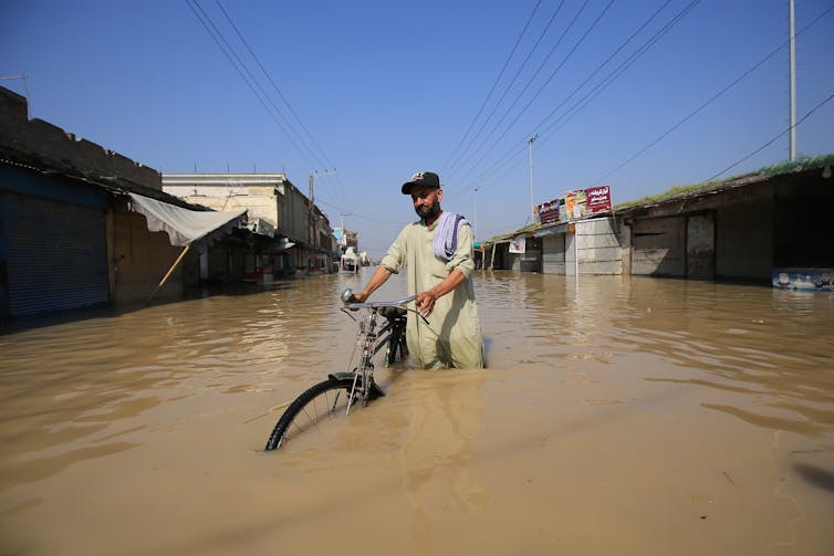 Man with bike wades through water