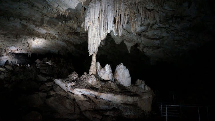 A group of stalagmite cones rise from the cave floor in a dramatic image