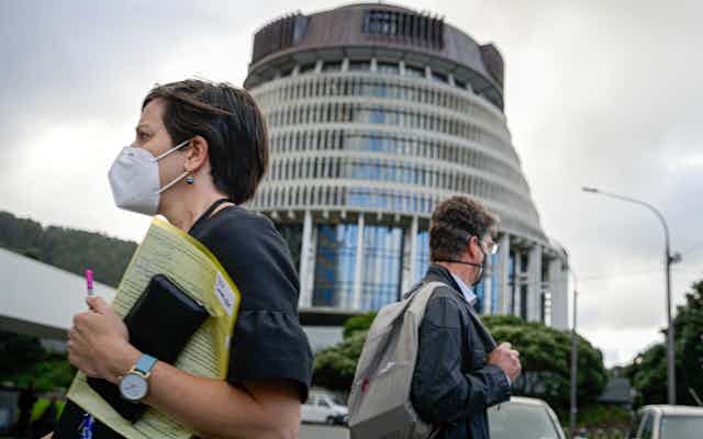 People wearing masks outside NZ's parliament.