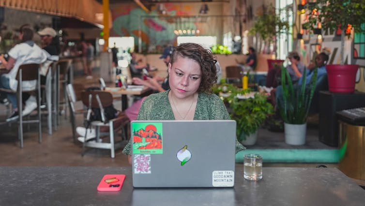 Woman at a laptop in an internet cafe