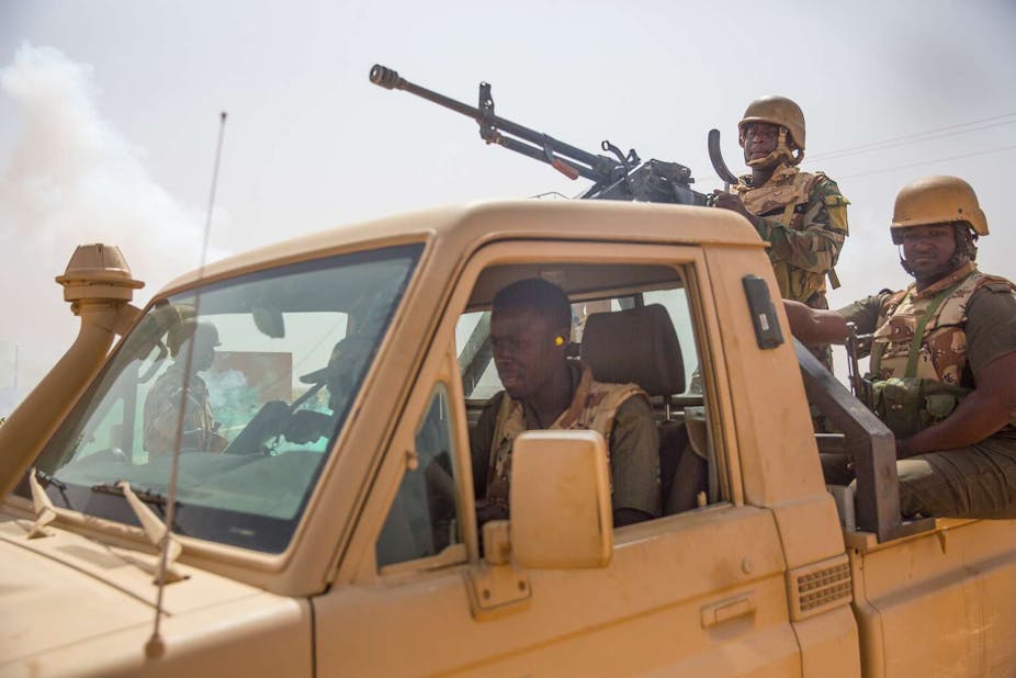 Soldiers sitting in a truck with a mounted gun