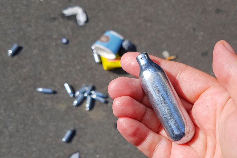 Hand holding a nitrous oxide canister