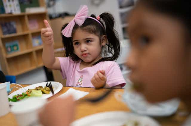 A child gives a thumbs-up