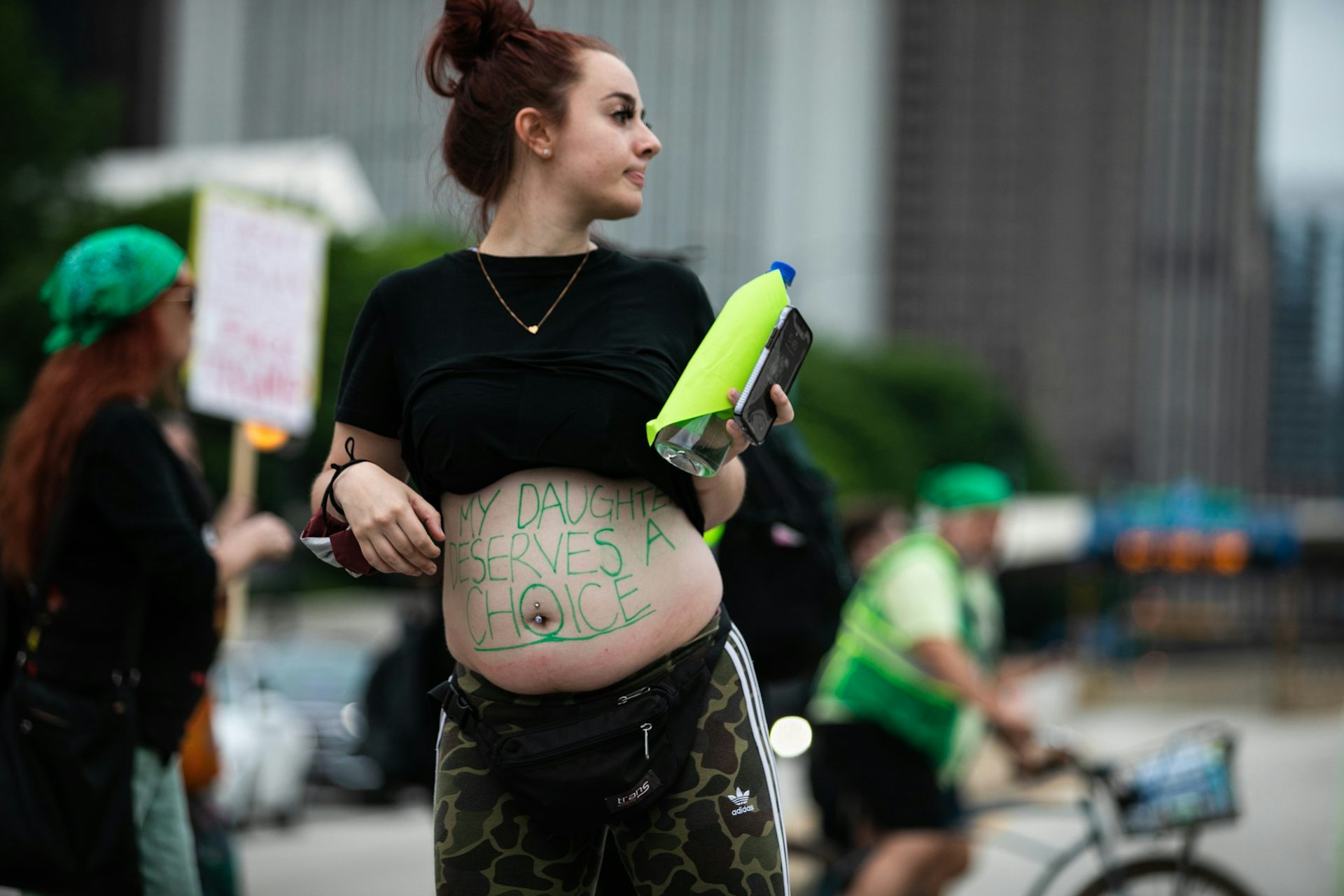 A pregnant person has a written message on the skin of her belly: 'My daughter deserves a choice'