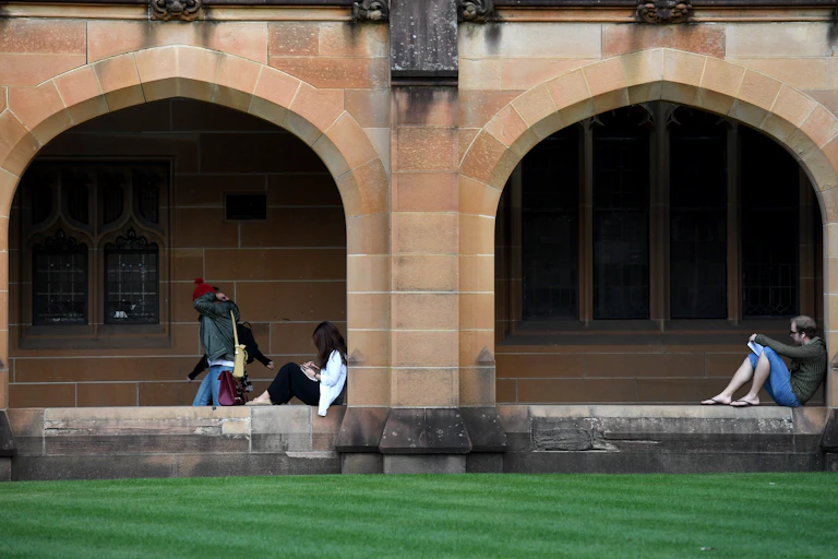 Students reading in university grounds.