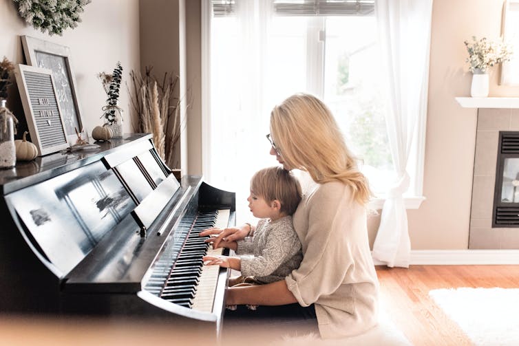 A mother and baby at a piano.