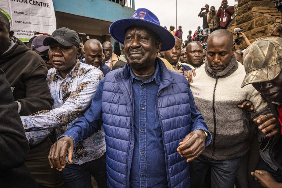 Raila Odinga leaves a polling station in Kibera Primary School after casting his vote