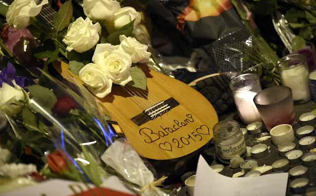 Guitare dans un parterre de fleurs devant la salle de concert du Bataclan, à Paris, deux jours après les attentats.