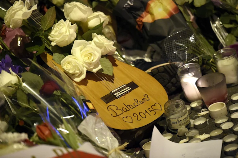 Guitare dans un parterre de fleurs devant la salle de concert du Bataclan, à Paris, deux jours après les attentats.