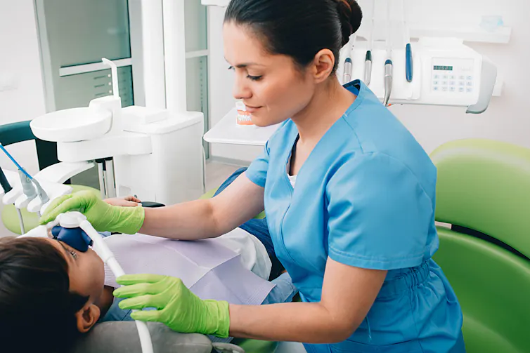 Paediatric dentist administering nitrous oxide to a patient