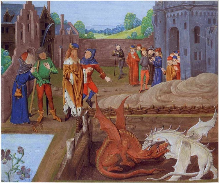 A medieval painting of people watching two dragons battle.