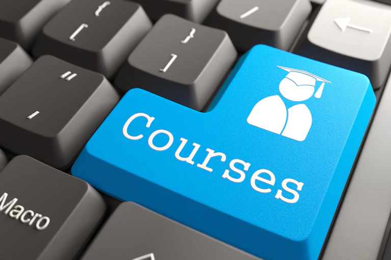 a blue key that says 'courses' is seen on a keyboard.