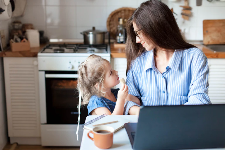 femme qui travaille sur un ordinateur portable regarde une petite fille