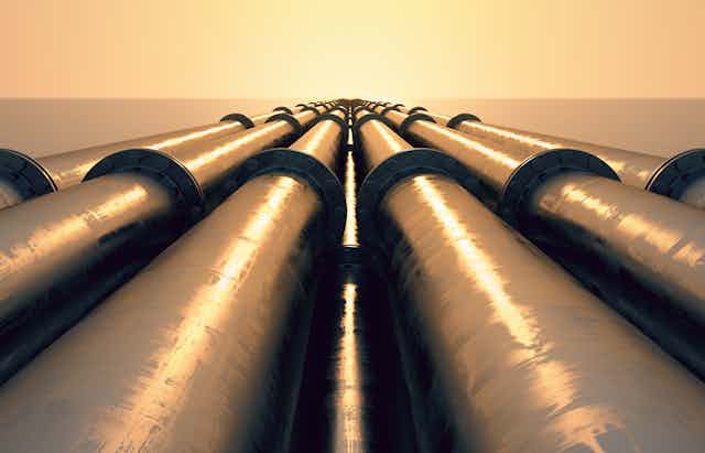 Tubes running in the direction of the setting sun. Pipeline transportation is most common way of transporting goods such as Oil, natural gas or water on long distances.