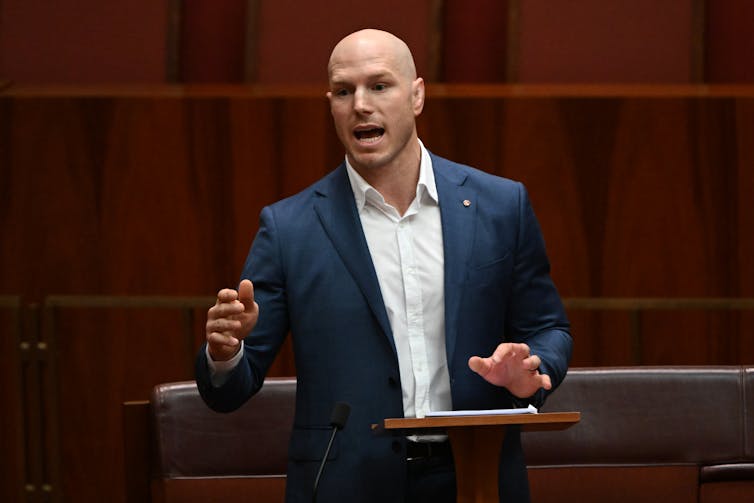 man speaks at lectern