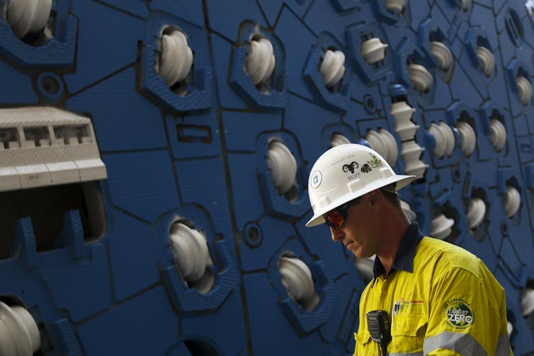 worker in hard hat in front of machinery