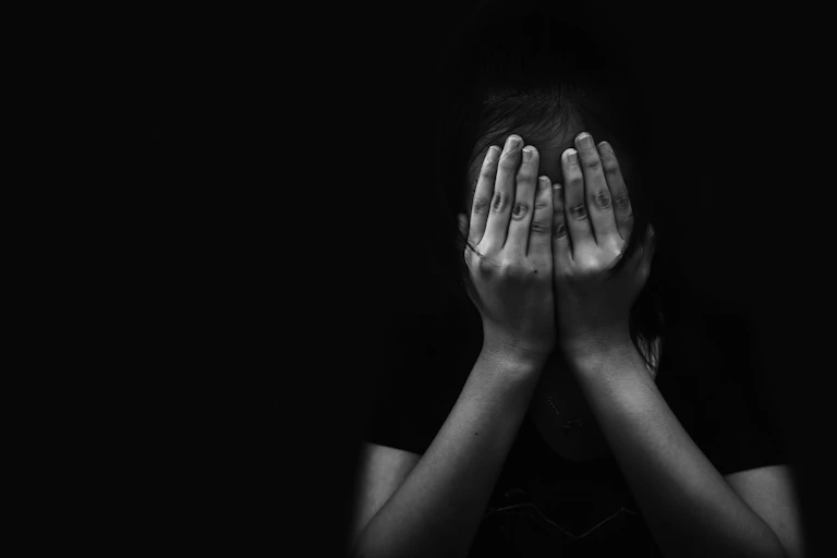 Woman covering her face with her hands