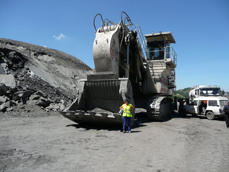 Woman standing in front of mining machinery