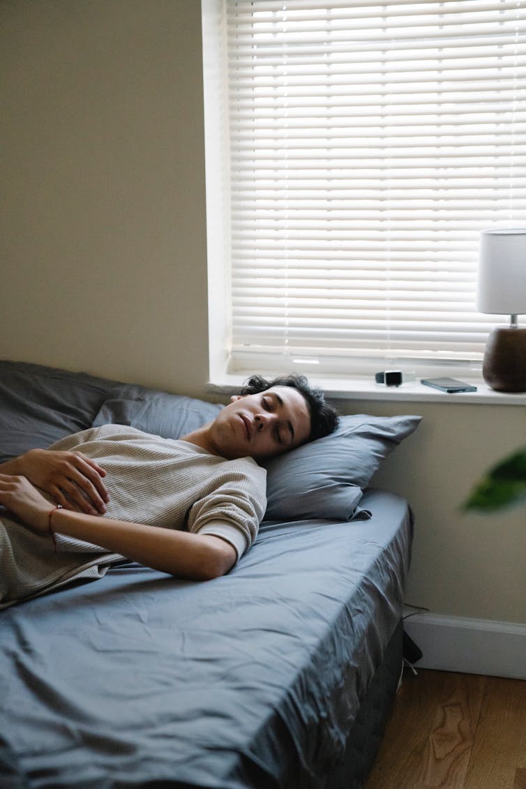 un homme dort dans un lit