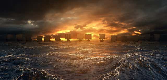 Viking ships sailing against a sunset
