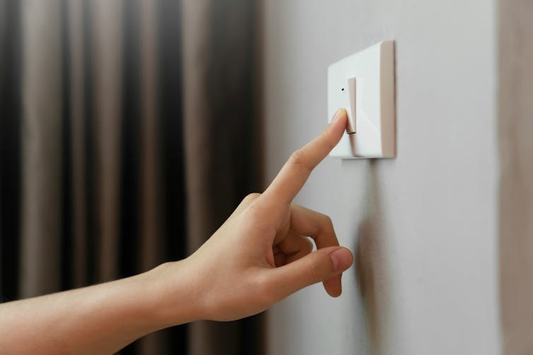 Close-up of a finger turning off a light switch