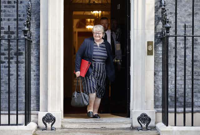 Smiling Therese Coffey walks out of Downing Street with a red folder under her arm, after the first meeting of Truss's cabinet